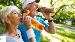 older couple drinking out of water bottles. They are staying hydrated